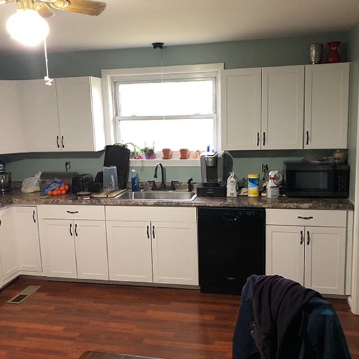 Kitchen interior after restoration showing dated cabinets and finishes