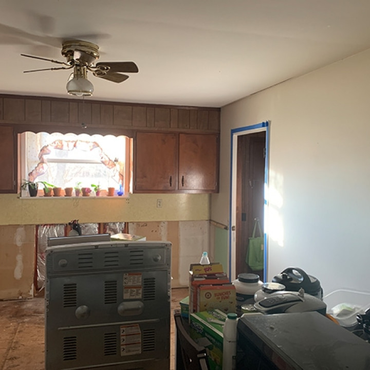 Basement or utility room before cleanup with stored items and potential damage