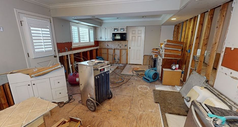 Water mitigation and drying equipment set up inside flooded basement