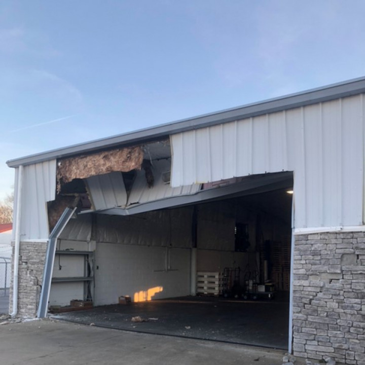 Commercial warehouse exterior with open bay door for large-scale restoration work