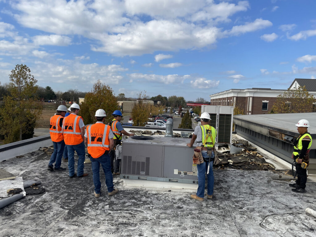 Commercial roofing and exterior restoration crew repairing rooftop HVAC and storm damage