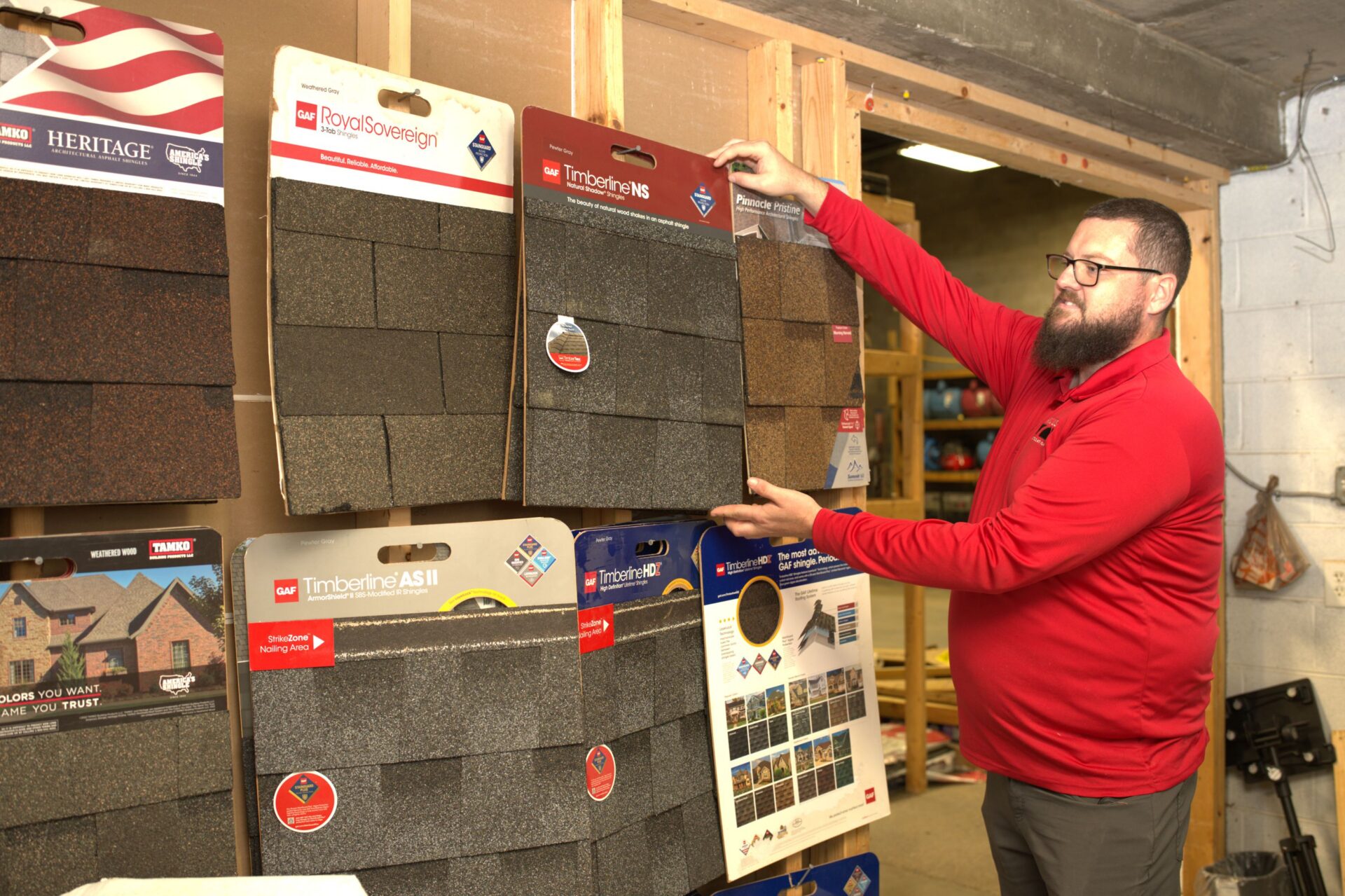 Arcus Restoration team member showing roofing shingle samples