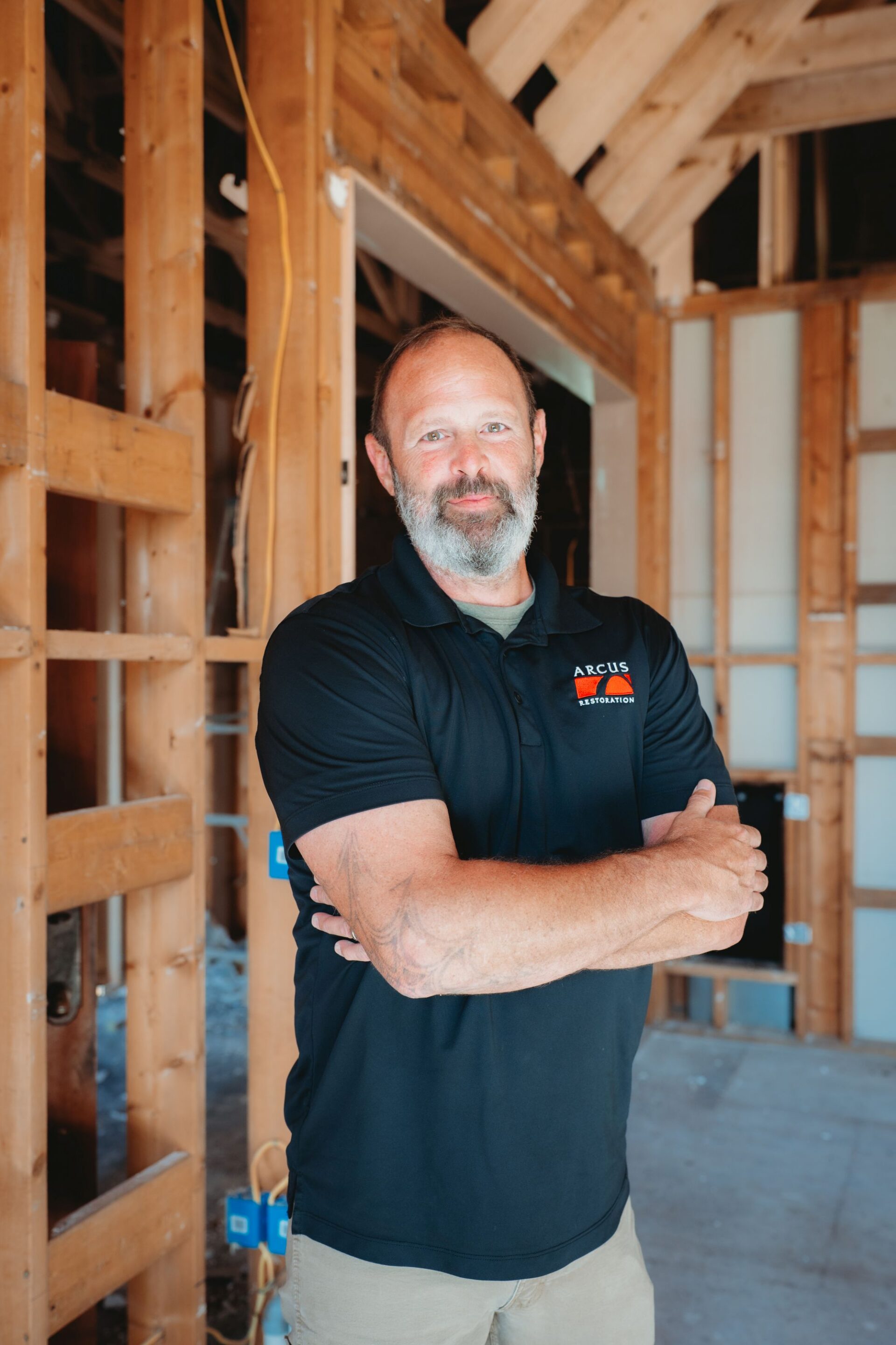 Arcus Restoration team member standing in a home under reconstruction