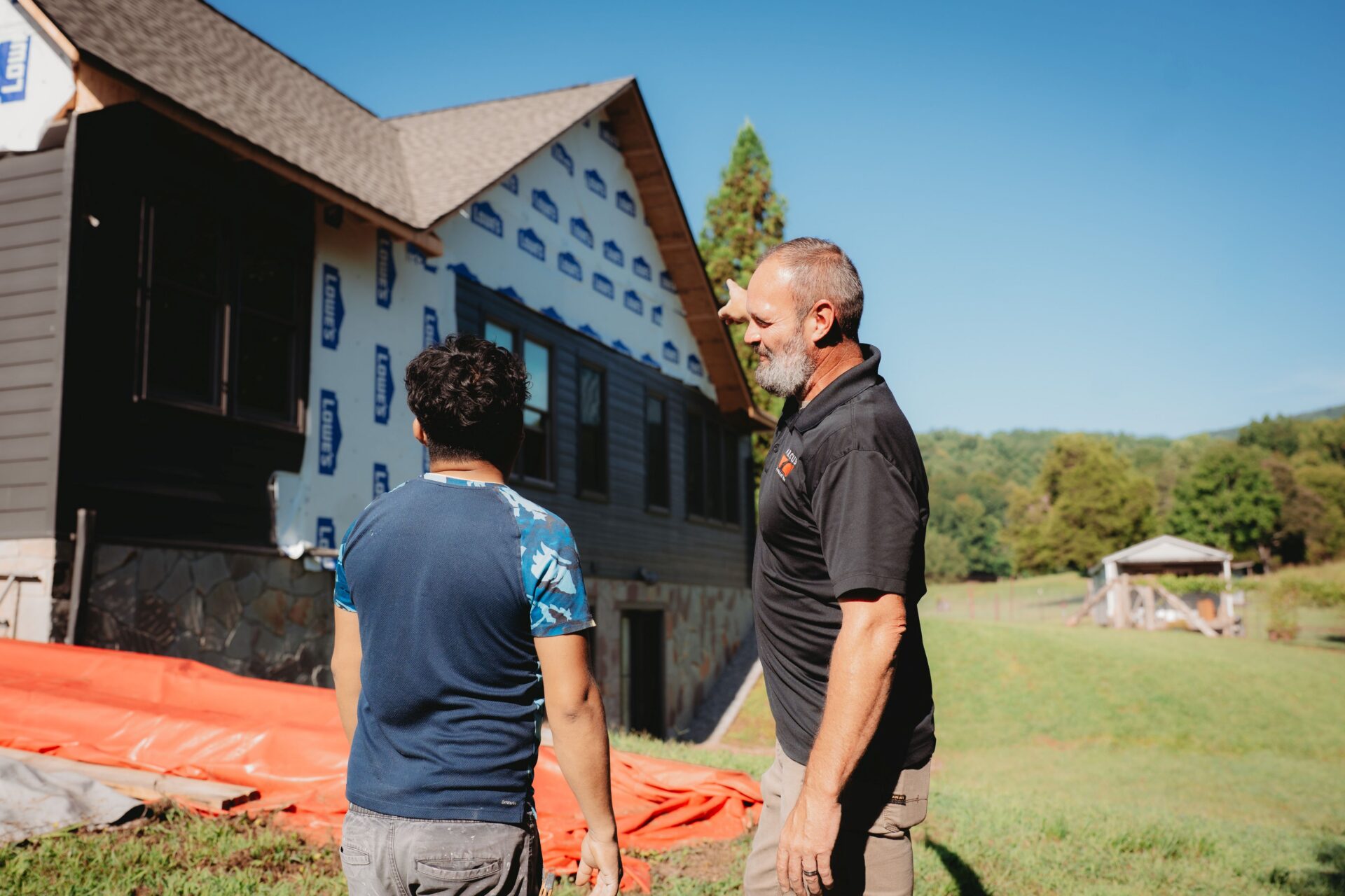 Arcus Restoration project manager talking with a homeowner outside a house under repair